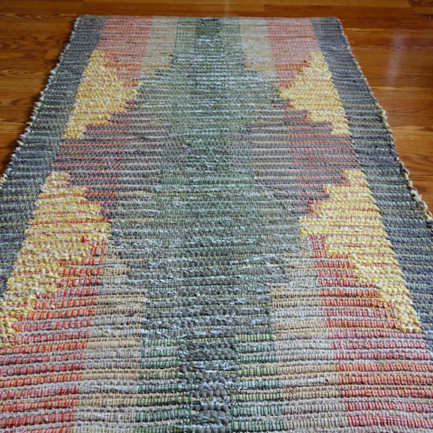 Custom rag rug. Symmetrical design in oranges, grays and yellows.