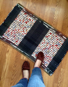 Navy rag rug with two multi-color stripes going up its height.