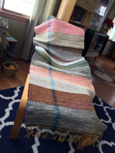 Rag rug woven by fiber artist Petra Guenthner Johnson. Vintage denim in alternating wide bands of pink, red, blue, and grey. Made with repurposed materials and cotton rug warp. Approximate size 3x11'.